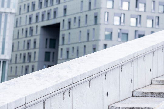 Minimal white concrete stairs with a blurred high rise facade creating a quiet urban composition of clean lines open space and contemporary architectural geometry
