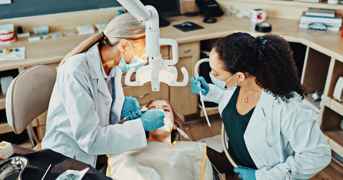 Dentist, team and patient in clinic for procedure, dental suction and drill for cleaning tooth decay. Orthodontics, women and help for oral hygiene, tools assistant and medical health with ppe