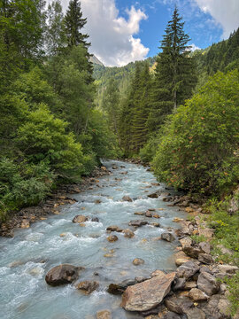 Alpine river flowing through forest in Les Contamines-Montjoie, France