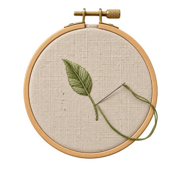 Embroidery hoop with a green leaf design on fabric being stitched with a needle and thread