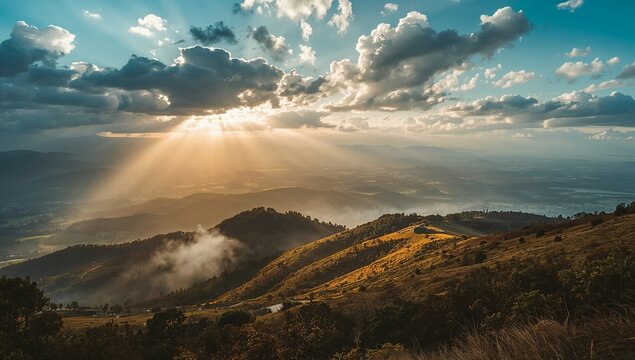 Breathtaking sunset over rolling mountain hills with golden sun rays breaking through dramatic clouds.