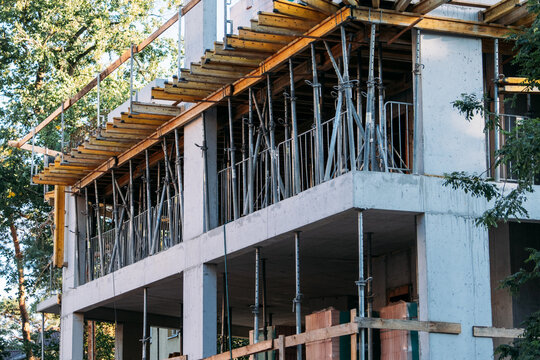 Concrete building under construction with timber formwork and steel props supporting slab. concrete slab formwork, telescopic shoring props, timber beam formwork system