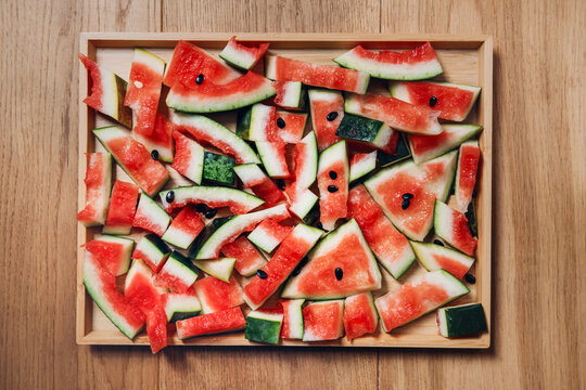 Summer background of leftover watermelon rinds and pieces scattered on surface. Sustainable food waste reduction, zero waste kitchen practices, using whole watermelon concept.
