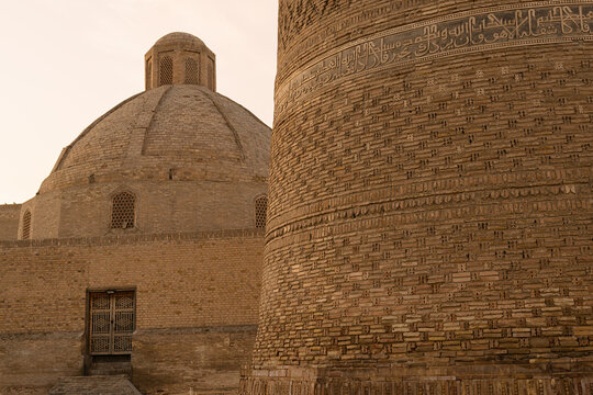 Kalyan Minaret brickwork and dome in Bukhara showing intricate Arabic calligraphy and medieval Islamic craftsmanship. Ideal for travel publications and heritage documentation.