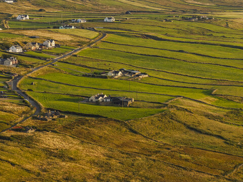 Aerial view of the rolling green fields and rural houses in the countryside of Doolin, County Clare, Ireland.