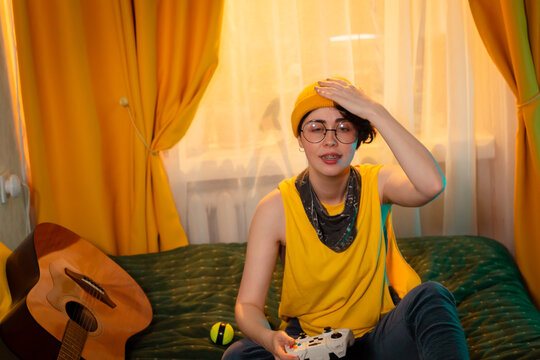 Teen girl smiles during a game in a warmly lit room. Concept of personal enjoyment and home leisure. Mid shot