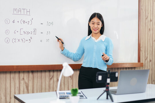 Female tutor standing in front of whiteboard and writing math eq