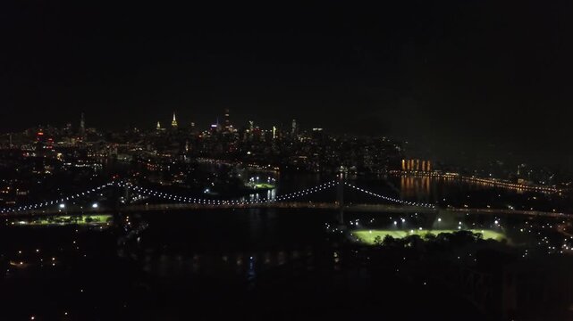 Stunning fireworks display over Astoria Park with New York City skyline and Hell Gate Bridge at night.