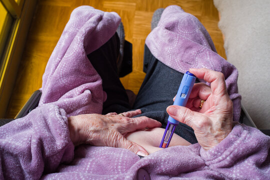 point of view of an elderly patient administering diabetes medication with an injection pen