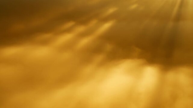 Golden clouds drift across glowing sky as sunlight rays emerge through haze