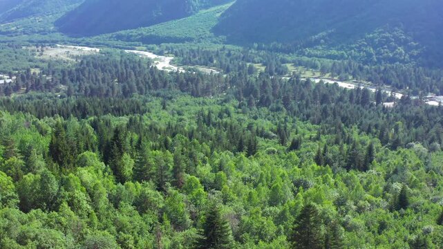 Dolra River curves in ascending aerial view above dense forest near Mazeri, Svaneti, supporting landscape mapping, ecotourism, watershed research and Georgian mountain travel promotion campaigns.