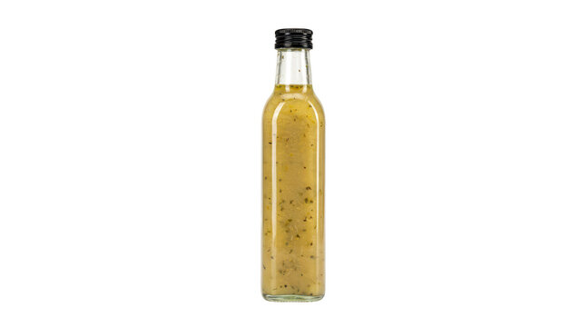 A tall, slender clear glass bottle filled with yellow salad dressing or vinaigrette, containing visible herbs and spices, with a black cap, isolated