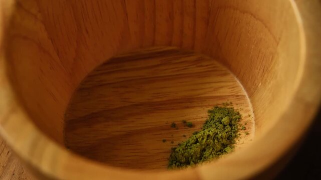 Scooping matcha powder into a bowl for preparation