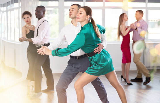 Elegant couples dancing tango, enjoying dance moves in dance salon