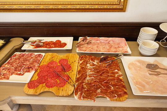 Assorted cured meats and cold cuts arranged on a buffet table