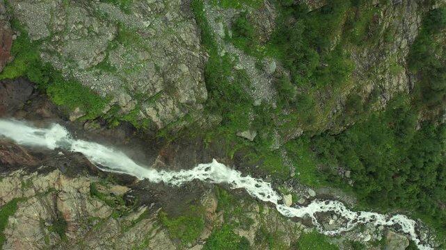 Shdugra stream surges in forward aerial view across a narrow rocky gorge below Ushba glaciers near Mazeri, Svaneti, supporting hydrology research, trekking tourism and alpine geography media.
