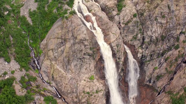 Shdugra Waterfall descends, aerial view across snow-fed rock channels below Ushba glaciers near Mazeri, Svaneti, supporting climate research, meltwater monitoring, trekking tourism, mountain geography