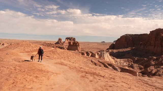 Woman and Dog on Hiking Trail in Goblin Valley State Park Utah USA, Dusty Trail to Goblin's Lair