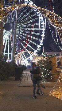 Two boys hugging and spinning at illuminated Christmas fair