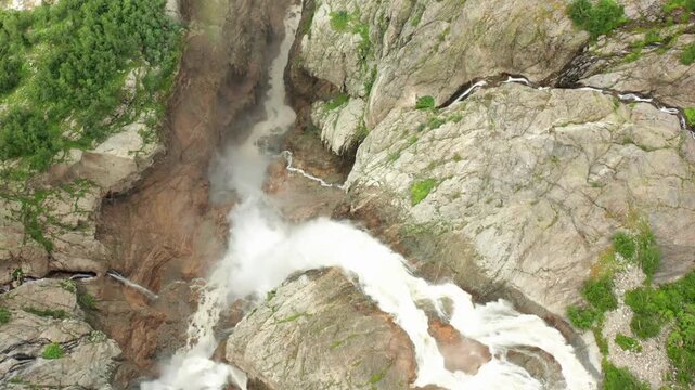Shdugra Waterfall pours aerial view through a narrow rock gorge below Ushba glaciers near Mazeri, Svaneti, supporting erosion monitoring, hiking tourism, freshwater research, Georgian travel campaigns