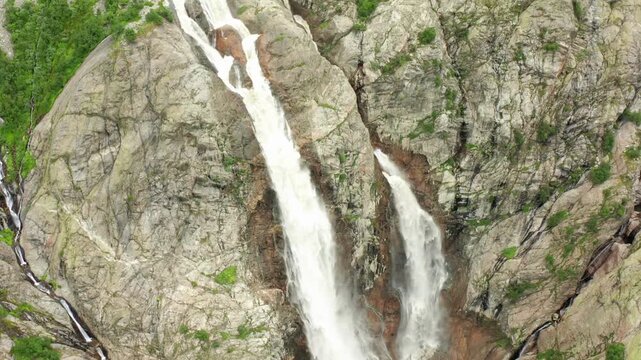 Shdugra Waterfall cascades in aerial view through a narrow granite chute below Mount Ushba near Mazeri, Svaneti, supporting adventure tourism, hydrology education, geology research, travel campaigns