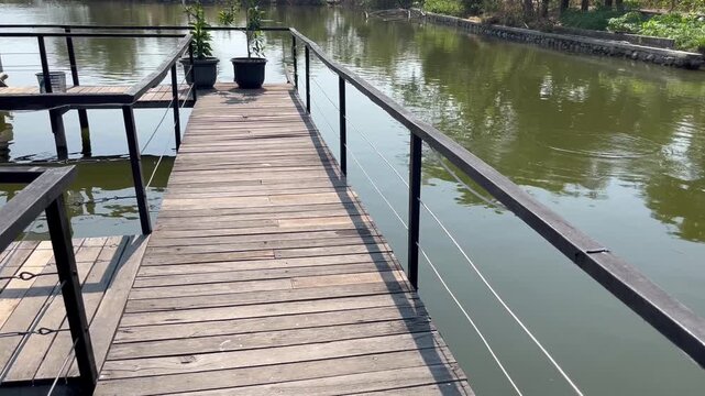 Modern Wooden Path with Black Metal Fence Near Pond