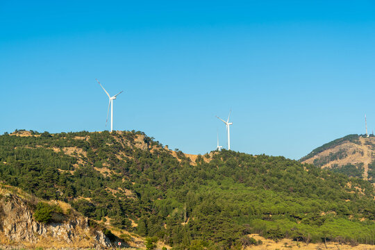 Wind turbines generating clean energy on a green hill