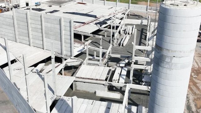 Modern Prefabricated Concrete Building Under Construction with Precast Columns Wall Panels and Hollow Core Floor Slabs, Aerial View in vertical video.