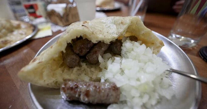 traditional Bosnian cevapi served with flatbread and onions in Bascarsija, Sarajevo, showcasing authentic Balkan street food and Bosnian cuisine.