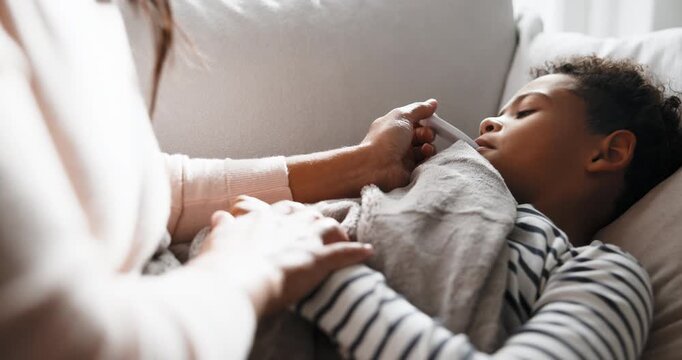 Sick, mom and kid in home with thermometer, childcare and health monitor with flu symptoms. Comfort, mother and child on couch with tech, parenthood and temperature check in illness assessment.