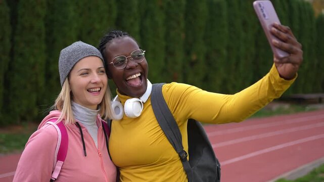 Diverse female friends taking a selfie at a running track