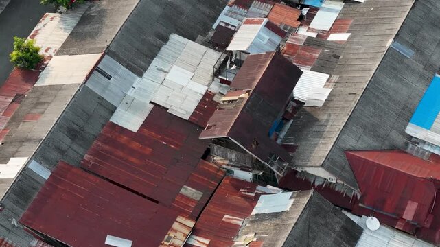 Dense residential neighborhood rooftops captured from above during a sunny daylight period