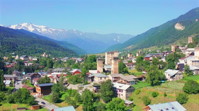 Mestia towers advance in aerial view across historic homes and Caucasus slopes, supporting heritage tourism, medieval architecture, cultural history and Georgian mountain destination promotion.