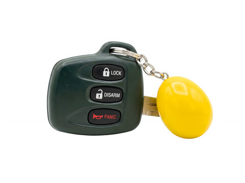 A black car remote key fob with a yellow plastic tag isolated on a solid black background