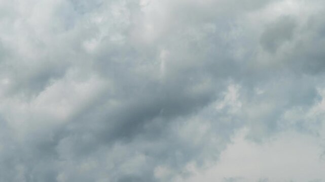 Dramatic time-lapse of dark, stormy clouds moving across a overcast sky, creating a moody atmospheric scene.