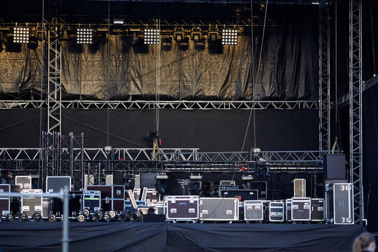 Concert stage setup empty lighting rig truss flight cases. Outdoor festival backstage equipment, spot lights, sound systems, production gear and technical stage construction background