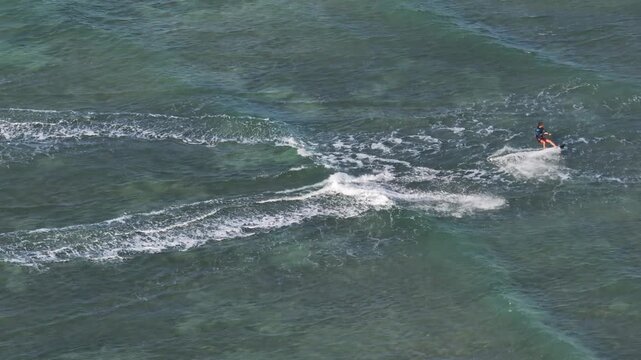 Aerial drone view of kite surfers riding the waves at My Hoa Beach in Vinh Hai, Khanh Hoa, Vietnam, showcasing a spectacular coastal landscape under bright sunlight.
