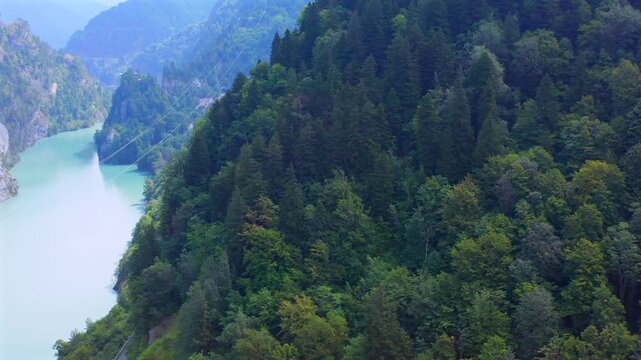 Drone takes off above Enguri Reservoir and forested mountain slopes in Svaneti, Georgia, supporting reservoir geography, landscape mapping, hydropower tourism and environmental media production.