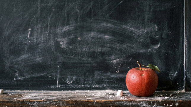 Close-up black chalk board in chalk stains chalk board and red apple, selective focus, copyspace