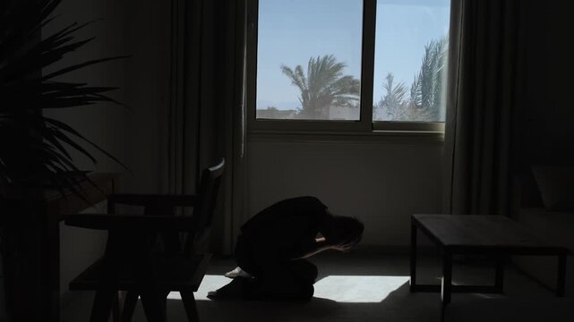 Distressed man falls to his knees and covers his face during an emotional collapse, expressing despair, helplessness and devastating realization in dramatic slow motion