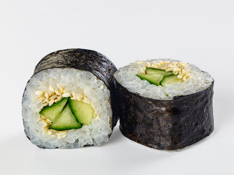 Sushi roll with cucumber and sesame seeds on white background
