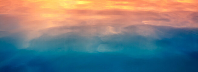 Fototapeta premium Seascape at sunset light. Calm sea water with clouds and sun reflection. Abstract nature landscape background