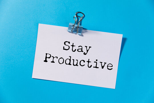 A notepad with a pen on a desk with a motivational message to stay productive