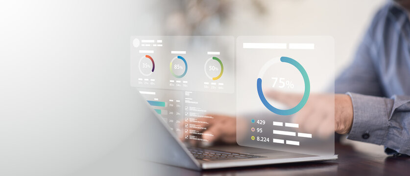 Corporate analyst evaluates financial performance metrics on holographic dashboard interface beside modern laptop demonstrating strategic data intelligence and business growth