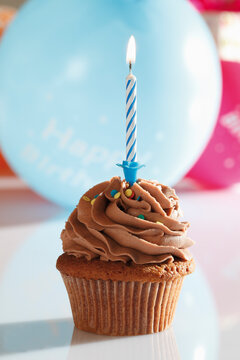 Close up of chocolate buttercream cupcake with birthday candle