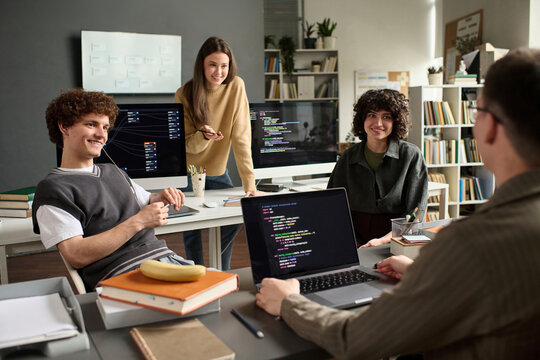 Male and female students discuss programming code in class