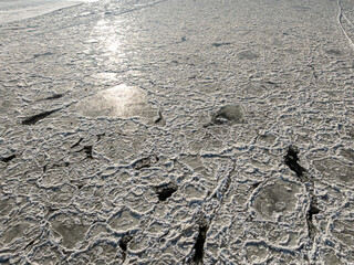 Fototapeta premium Ice floe drifting on frozen Brda River at sunrise.