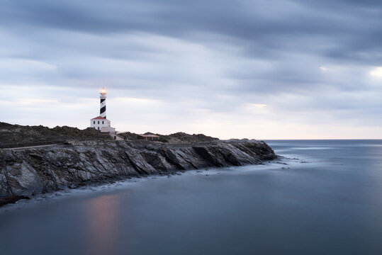 Spain, Balearic Islands, Menorca, Favaritx lighthouse surrounded by clouds in the morning