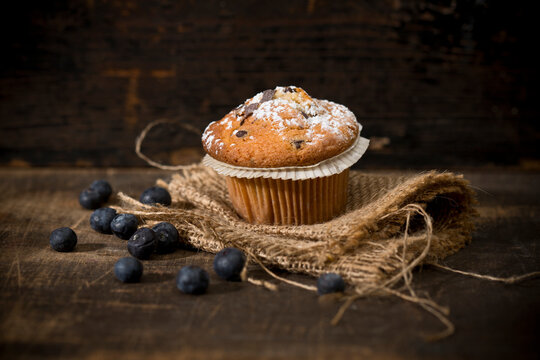 Blueberry muffin, jute and blueberries on wooden table