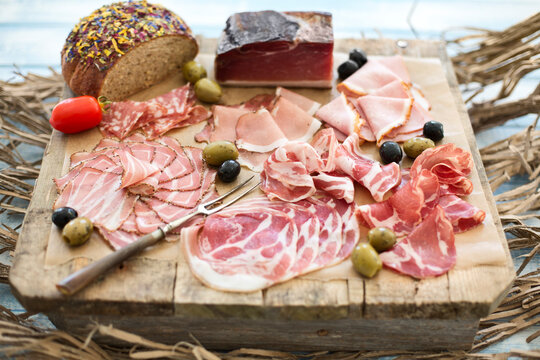 Cold snack, flower bread, olive, tomate and different sorts of bacon, pork roast with crackling and pancetta